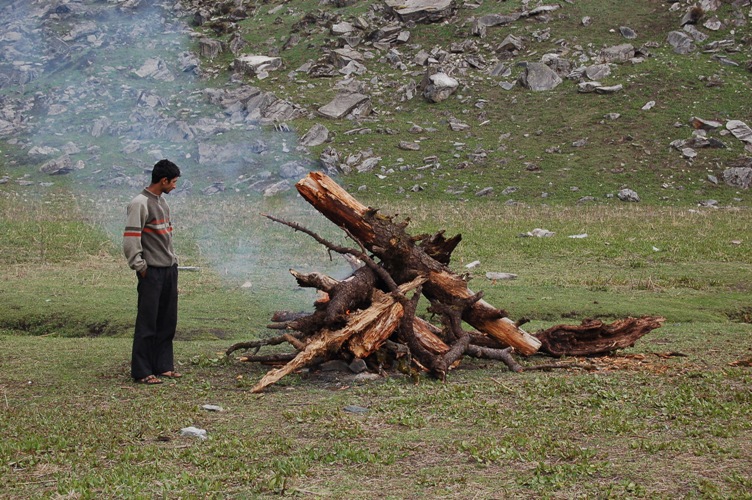 A big camp fire... (he is not a midget)